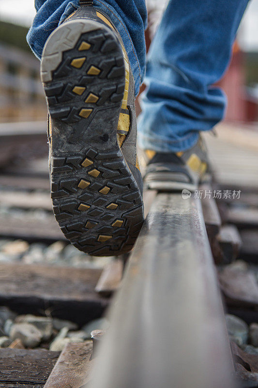 在铁轨上行走的人靠在鞋上