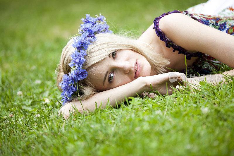 美丽的年轻女子在草地上休息
