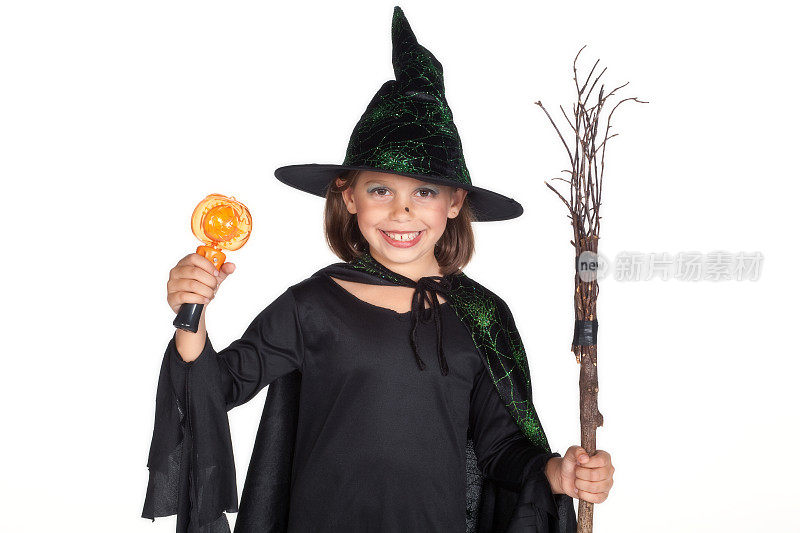 年轻的女孩穿着女巫服装拿着扫帚和灯。