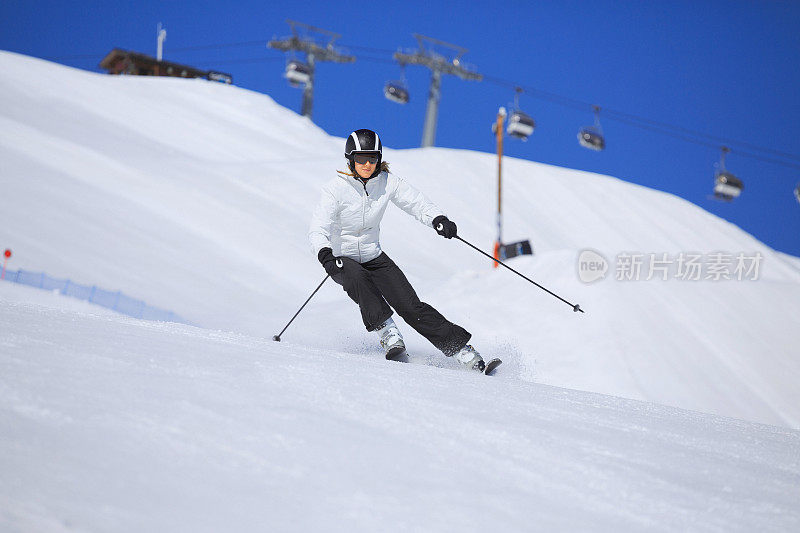 在阳光明媚的滑雪胜地滑雪的中年妇女滑雪