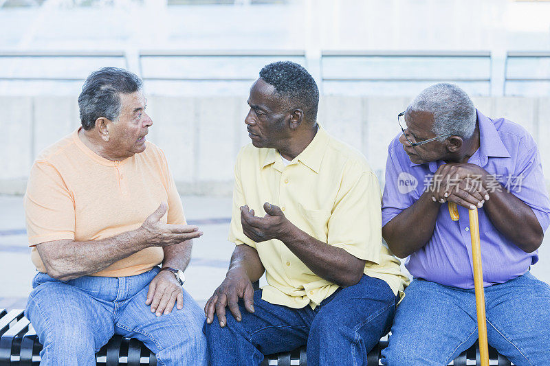 三位不同种族的资深人士在长椅上争论