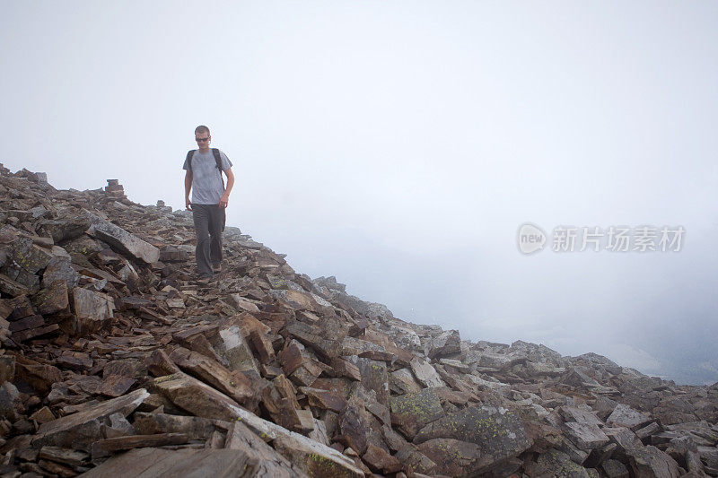 一名男子徒步走出树林上空的大雾。