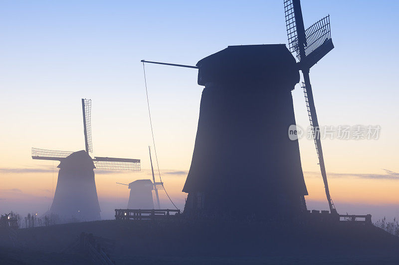 传统的荷兰风车在冬天的日出