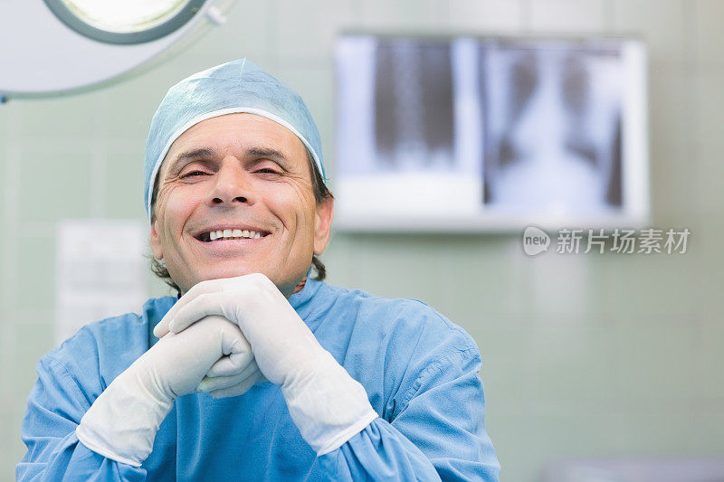 微笑的外科医生靠在拳头上