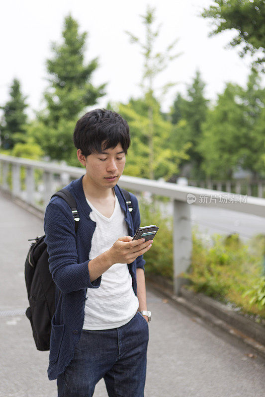 年轻的日本学生在日本京都查看智能手机