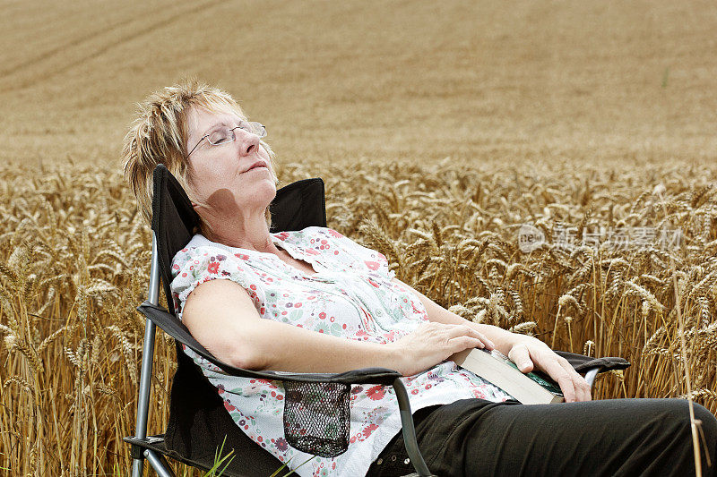 一个成熟的金发女人在玉米地里打瞌睡