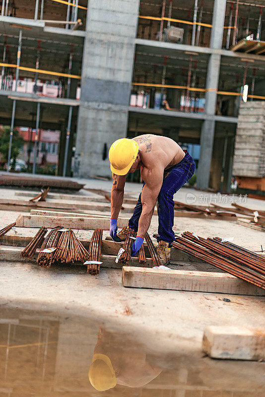 肌肉赤裸的建筑工人在建筑工地工作