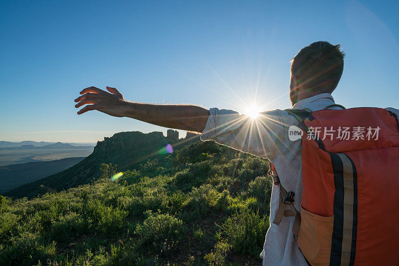 年轻人在山顶上张开双臂