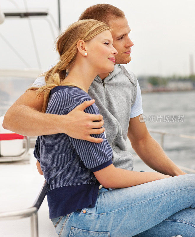 快乐的年轻夫妇在帆船上享受海上航行
