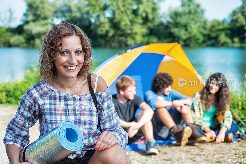 露营:帐篷前的女孩。朋友的背景