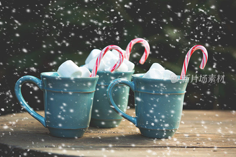 雪花落在可可杯和拐杖糖上