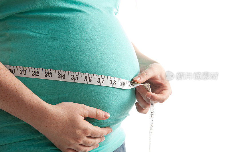 一名孕妇在测量自己的肚子