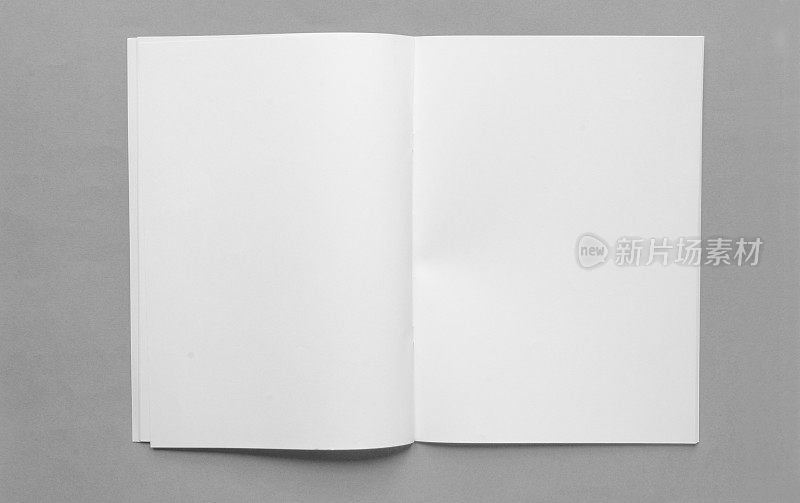 打开空白的宣传册与灰色平原的背景空白空间