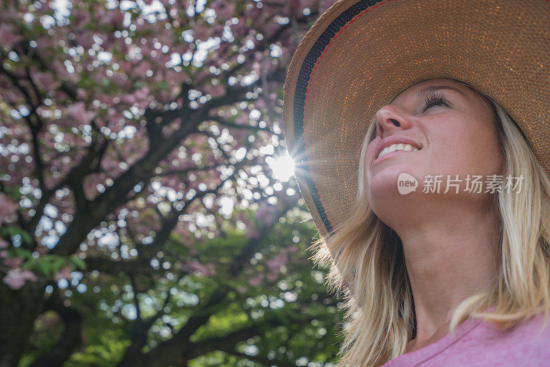 日本花园中年轻女子的肖像，春天的樱花