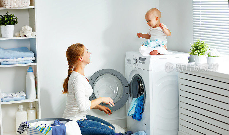 母亲家庭主妇与婴儿从事洗衣折叠衣服到洗衣机