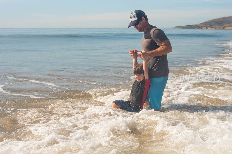 父亲和儿子在加州的阳光下玩冲浪