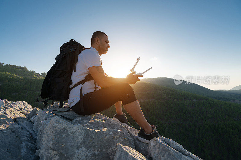 在高山上驾驶无人机的徒步旅行者