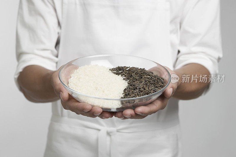 厨师端着一碗白米饭和野米饭(中间部分)