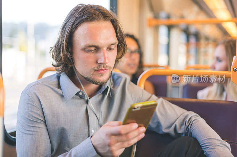 千禧年男性乘坐火车，用耳塞听播客