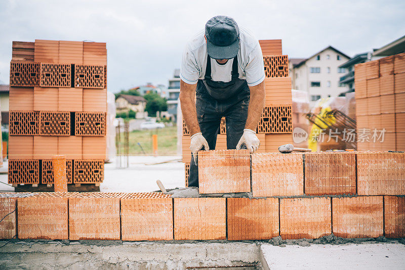 工业砌砖工人在建筑工地安装砖的细节