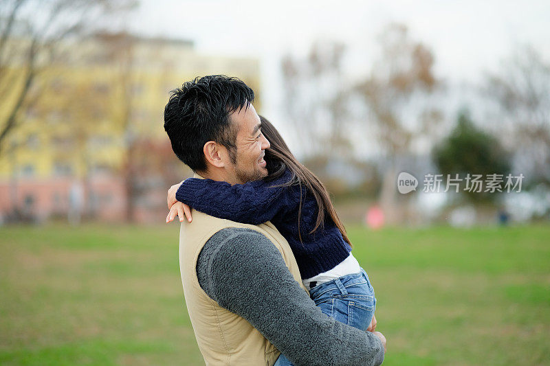 父亲在公园拥抱女儿