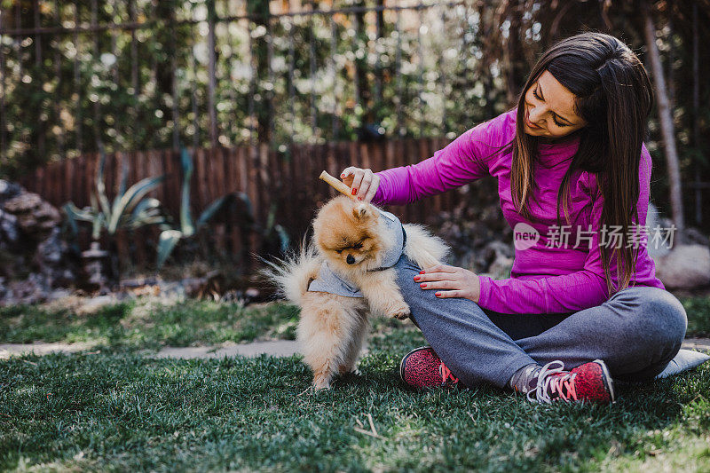 微笑的年轻女子和她的博美犬