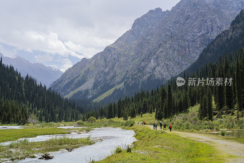 游客，男人和女人，徒步在山坡上阿拉库尔湖在喀喇昆仑山，吉尔吉斯斯坦