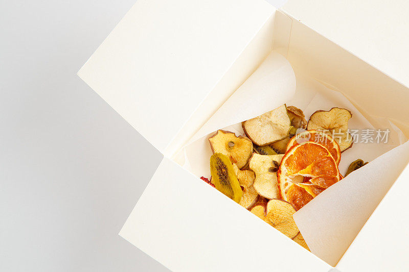 干橘子，香蕉和苹果在白色的背景白盒