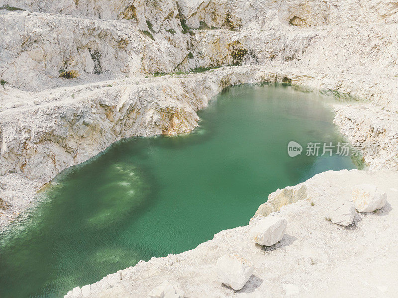 废弃的大理石采石场与绿松石色的水池塘在底部。鸟瞰图