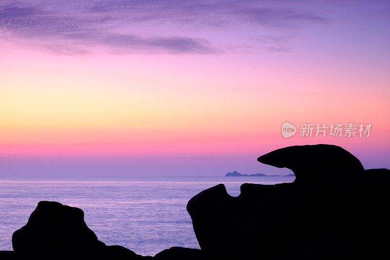 日落时分，法国布列塔尼粉红色花岗岩海岸的岩层