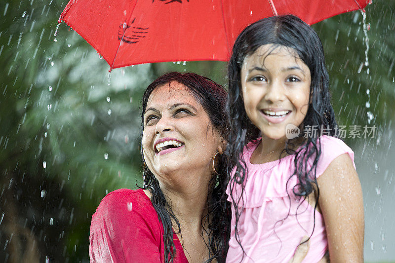 快乐的母亲和女儿在雨中
