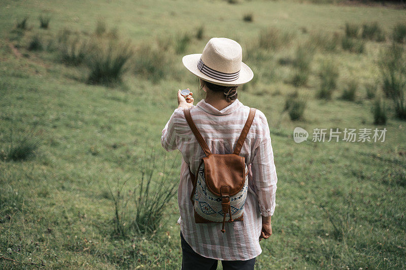 回归自然。独自寻找道路的旅行者。一个快乐的年轻女游客漫步在大自然中。阳光明媚的日子里在森林里的户外享受。