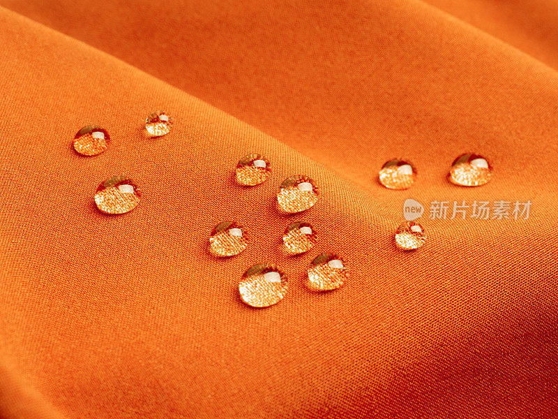 橙色防水织物与水滴近距离