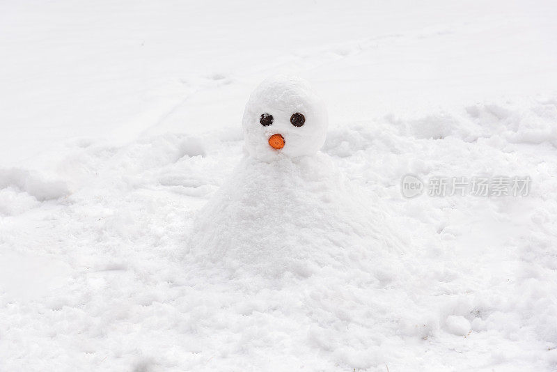 小雪人穿着白色的衣服在下雪的天气里