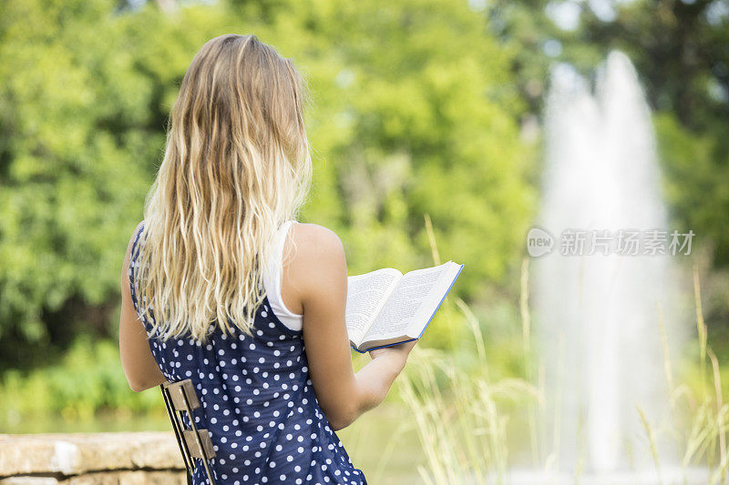 一个陌生的年轻女子在户外看书