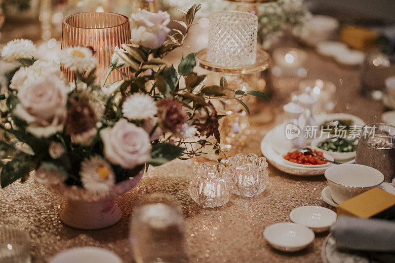 豪华精致的餐桌上装饰着金色主题蜡烛、桌布