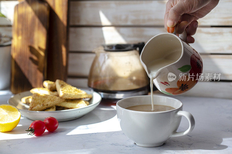 在家的咖啡休息时间:往咖啡杯里倒牛奶