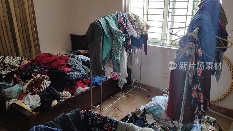 一个十几岁女孩的卧室里乱七八糟的，包括衣服和包
