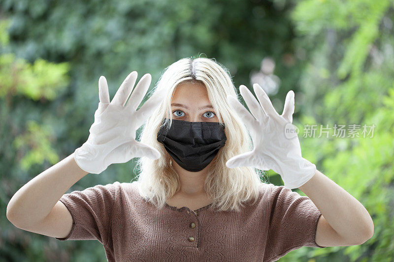 戴着手套的蒙面女人抵御病毒