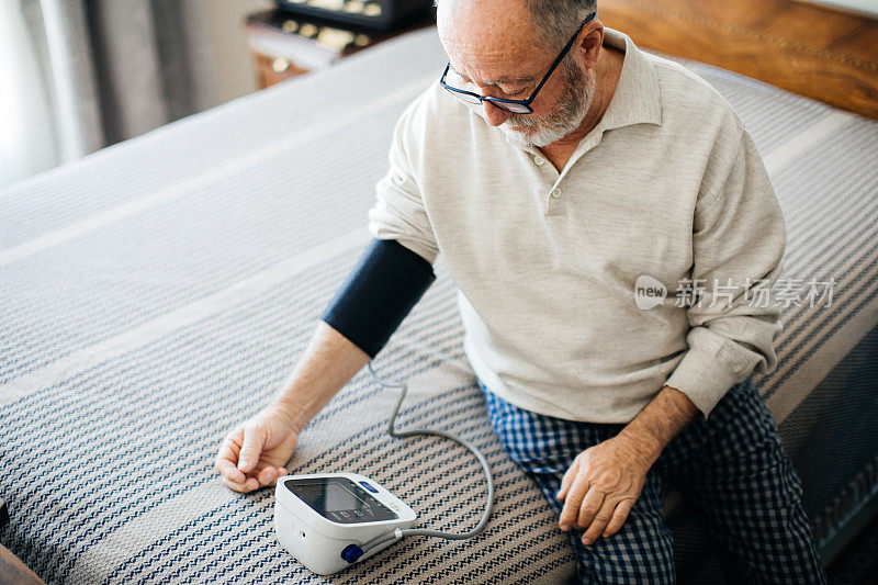老年活动者在卧室用血压计测量血压