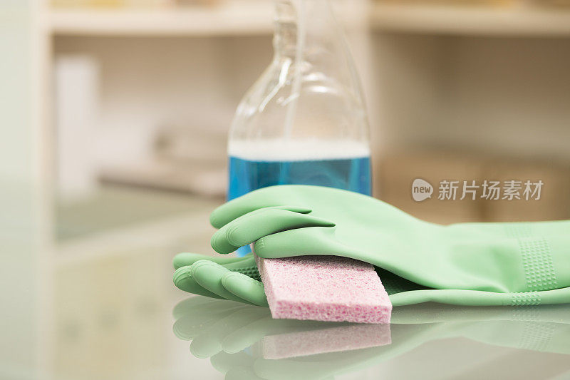 用手套、海绵和消毒剂清洁桌面。