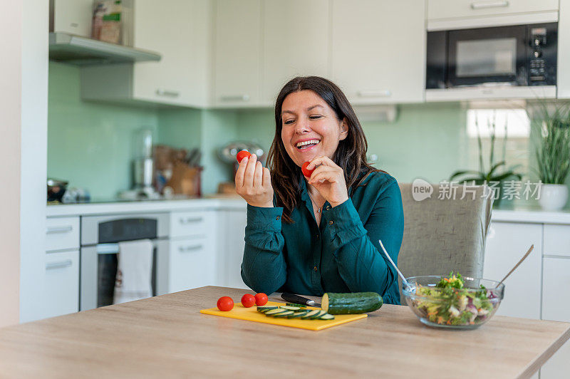 成年妇女在家庭厨房里准备健康食物