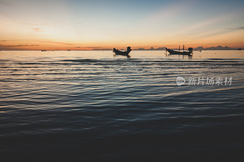 夕阳西下时，长尾船停泊在泰国高涛的海上