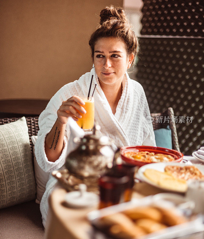 坐在桌边准备吃水果自助早餐的女人