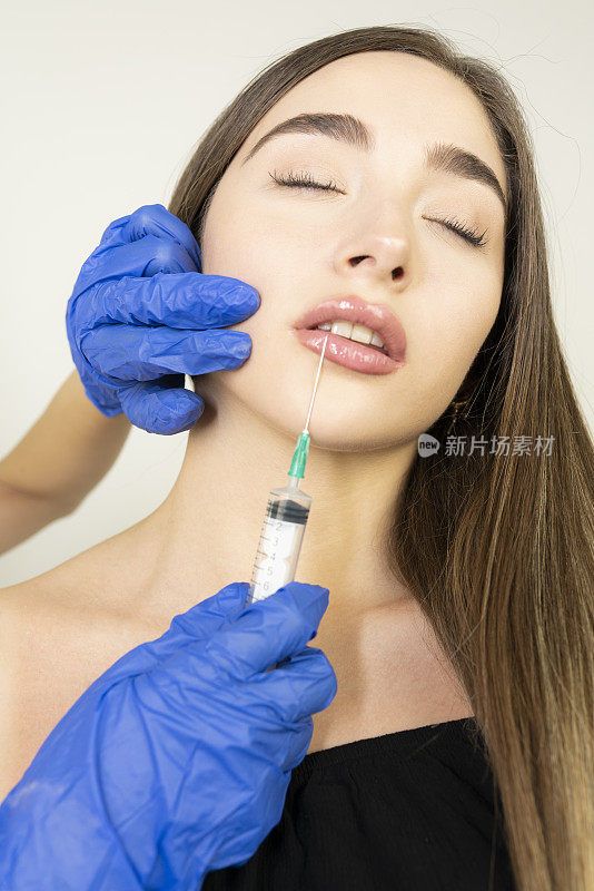 年轻女子在嘴唇上注射。在美容院的女人。整形外科诊所