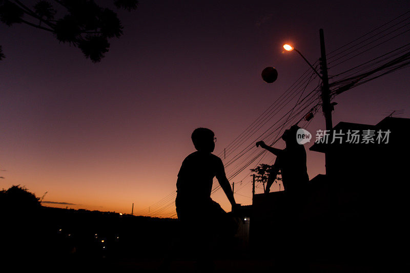 库里提巴，Paraná，巴西——两个男孩在街上踢足球。
