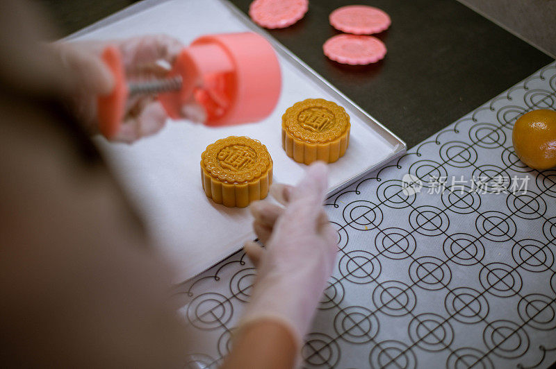 在烘烤前的烤盘上，女人们正在制作自制月饼糕点的面团