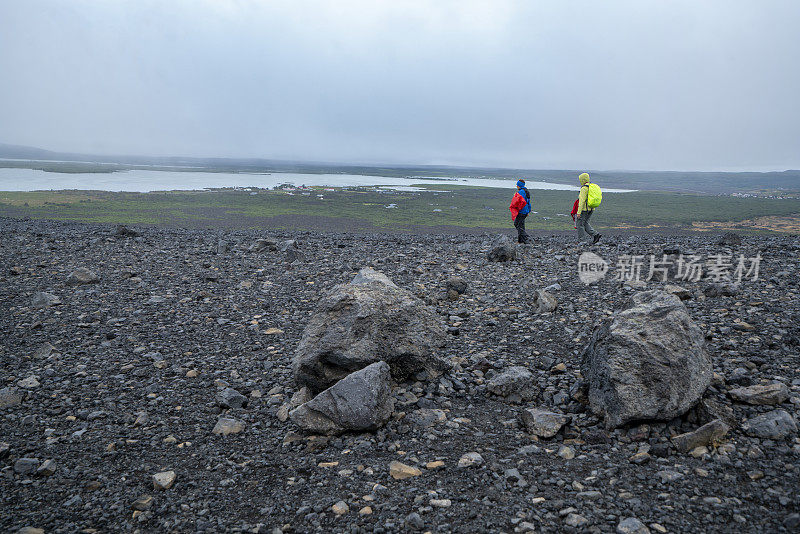 游客，两名女子在冰岛北部的赫弗尔火山口徒步旅行。