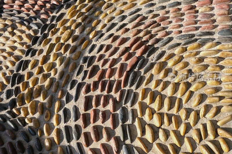 足底按摩用的脚底按摩鹅卵石路的碎片。马赛克圆形图案由凸面圆形卵石石块组成。地面路径纹理表面卵石
