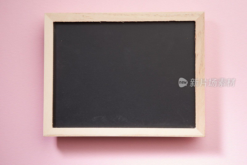 粉红色背景上的小白黑板